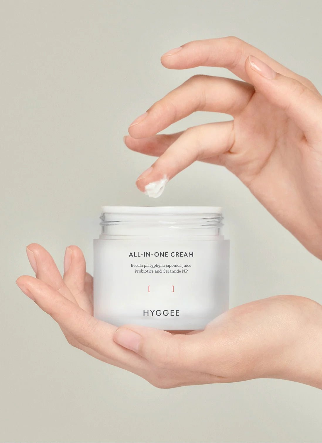 HYGGEE All-In-One-Cream being held and some product one a finger