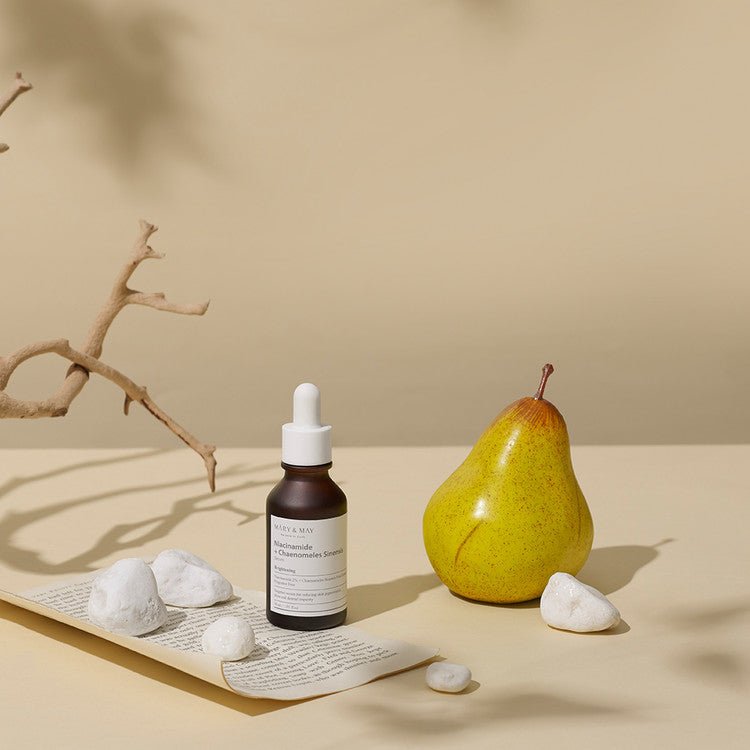 Mary&May Niacinamide + Chaenomeles Sinensis Serum far away photo of bottle with pear in background