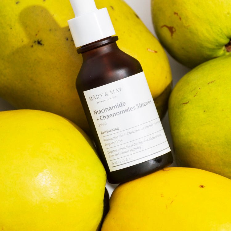 Mary&May Niacinamide + Chaenomeles Sinensis Serum close up of bottle sitting on limes
