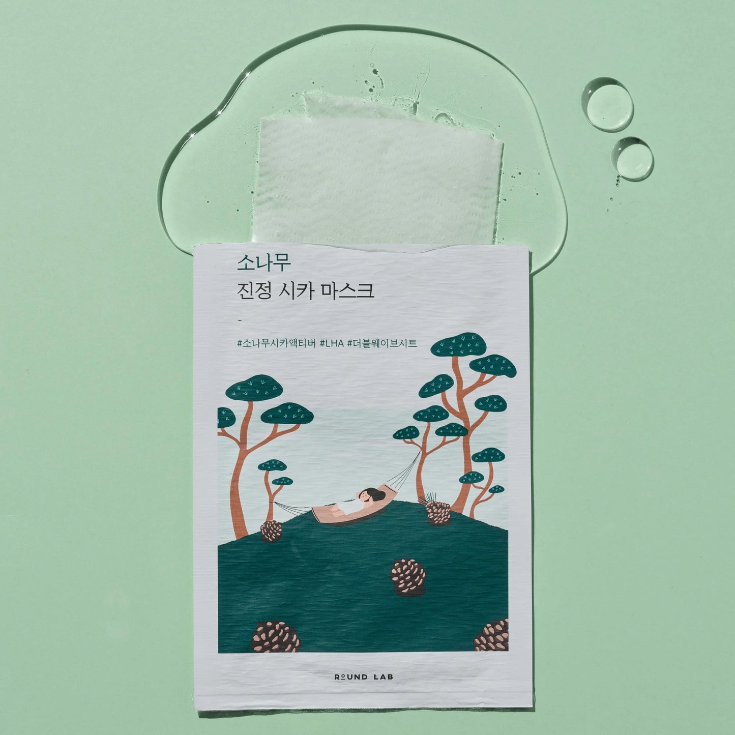 Round Lab Pine Tree Calming Cica Mask open and spilling out on a green background